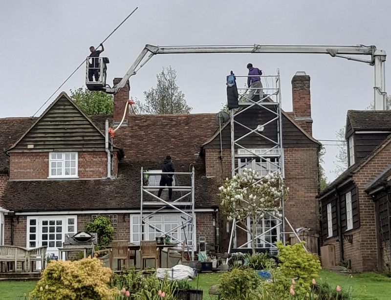 The Moss Cleaners using cherry picker and scaffolding to clean roof safely and professionally in Pulborough, West Sussex